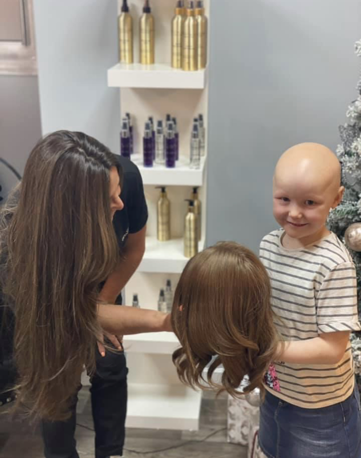 Bald kid holding new wig